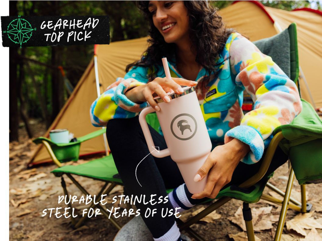 A person sits in a camp chair in front of a large tent. Text overlay reads: Gearhead Top Pick, durable stainless steel for years of use.